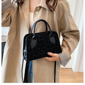 Detail of black leopard print tote with textured finish and reinforced top handles