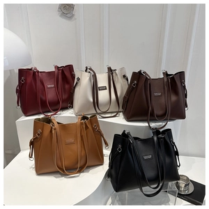 Group display of high-capacity tote bags in burgundy, cream, brown, and black colors