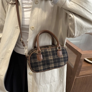 Retro-Karo-Umhängetasche mit braunem Lederbesatz, getragen zum beigen Trenchcoat