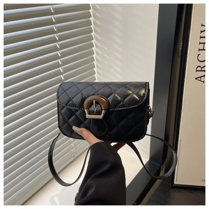 Detail der schwarzen Stepptasche mit runder Holzschnalle und feinen Nähten für Damen