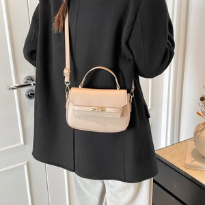 Minimalist beige PU leather crossbody bag with gold twist lock and adjustable strap
