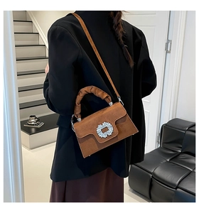Détail du sac en daim marron caramel avec boucle en strass et poignée nuage plissée