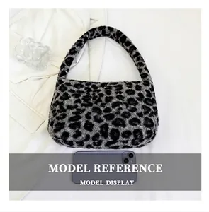Detail view of leopard print plush shoulder bag shown with smartphone for size comparison