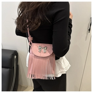 Detailed view of pink leather tassel shoulder bag with a silver butterfly ornament
