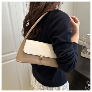 Detail showing contrast color leather shoulder bag with elegant gold buckle clasp