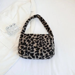 Detail of plush leopard print shoulder bag on white blazer with glass decor