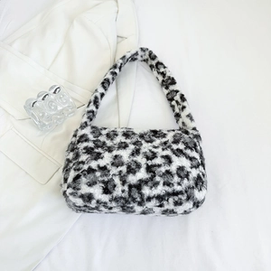 Flat lay of a plush black and white leopard print tote bag with soft faux fur texture