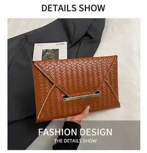 Détail de pochette enveloppe tressée marron avec boucle en métal doré haut de gamme