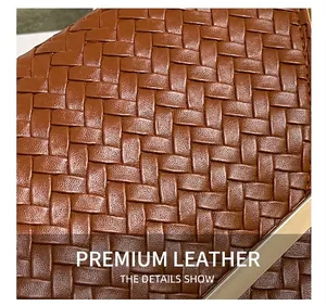 Zoom détaillé sur la texture en cuir tressé marron avec bordure dorée élégante de la pochette
