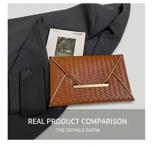 Pochette enveloppe tressée marron avec boucle dorée à côté d'un smartphone pour comparer la taille