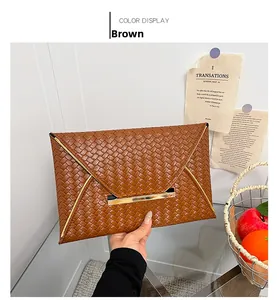 Détail de la pochette enveloppe tressée marron avec élégante garniture en métal doré