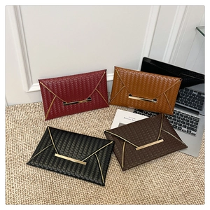 Détail de quatre pochettes enveloppes tressées en bordeaux, fauve, noir et marron avec or