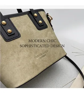 Detail of khaki canvas tote with black leather trim and gold rivets on the side