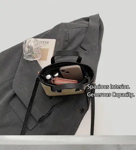 Detail view of spacious bicolor leather bucket bag interior on a gray blazer suit