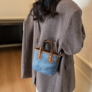 Sac seau vintage en daim bleu avec poignées en cuir marron et bandoulière réglable