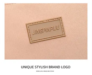 Close-up of the woven twill texture and logo patch on the peach nylon shoulder bag