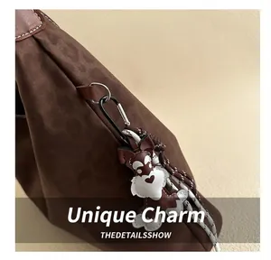 Close-up of leopard textured brown tote with a leather schnauzer bag charm and metal D-ring