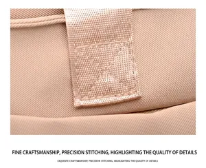 Macro shot of cross-stitched reinforced seams on a durable beige nylon shoulder bag strap