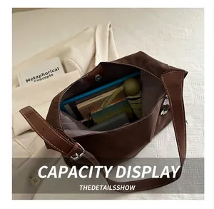 Detailed interior view of a large tote bag holding books and a daily umbrella