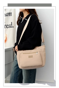 Beige large capacity nylon crossbody bag worn by model showing casual style