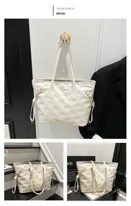 Detail of white tote bag featuring embossed bow patterns and adjustable side drawstrings