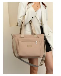 Adjustable shoulder strap and durable nylon handles on khaki functional tote bag