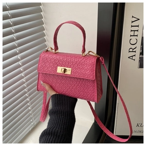 Close-up of rose pink croc-embossed handbag with elegant gold twist-lock and slim strap