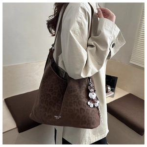 Detail of vintage leopard print hobo bag in brown suede with cartoon dog charm