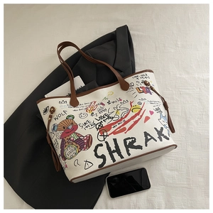 Vue de dessus d'un grand sac cabas avec graffitis, anses marron foncé et boucles latérales