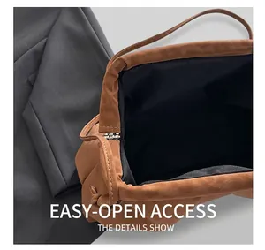 Close-up of the metal frame closure and black interior lining of the brown suede handbag