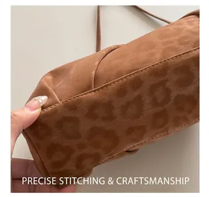 Close-up of precision stitching on the bottom of a brown leopard print suede handbag