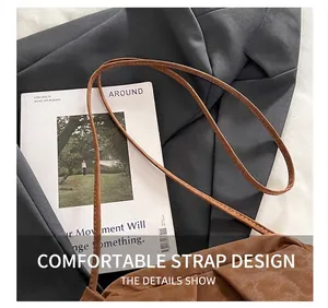 Detail showing the comfortable leather shoulder strap and pleated texture of the brown bag