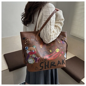 Detail of a large brown leather tote bag with artistic graffiti and bear prints