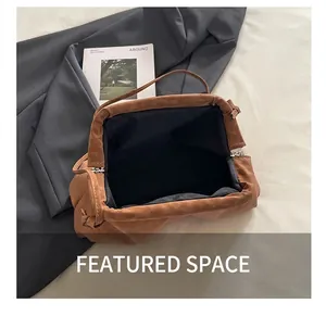 Detail showing the spacious black fabric interior and tie closure of the brown cloud bag