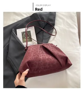 Detail of red leopard print bag with pleated texture on white fabric backdrop