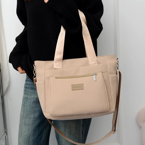 Large beige nylon tote bag with multi-pocket design and adjustable shoulder strap for women