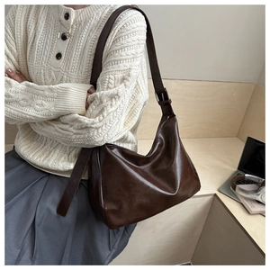 Sac hobo marron en simili cuir assorti à un haut en tricot blanc et jupe grise