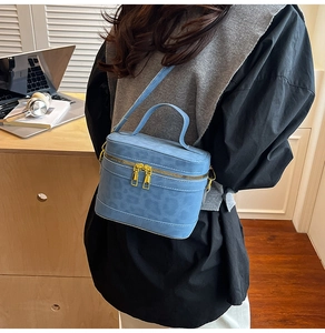Details der blauen Zylindertasche mit Leopardenmuster und Metall-Doppelreißverschluss