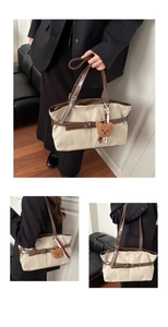 Close-up of contrast canvas tote with leather straps and cute plush bear keychain