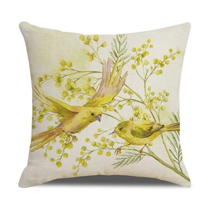 Detail of floral bird print cushion cover with yellow flowers and green leaves