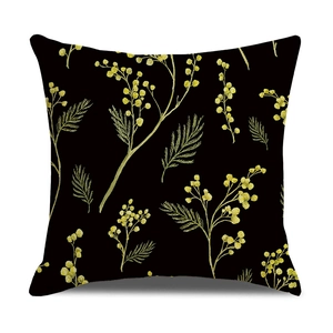 Macro shot of black throw pillow case with golden yellow mimosa floral pattern details