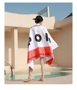 Detail of a microfiber sand-free beach towel featuring bold red and white sport design