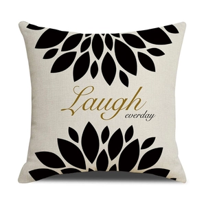 Detail von Leinen Kissenbezug mit Laugh everyday Druck und schwarzen Blumenmustern