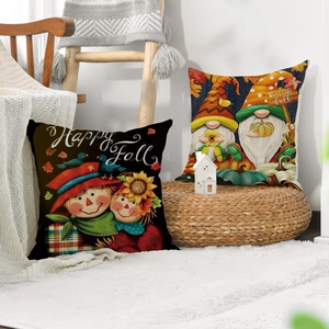 Close-up of linen pillow covers with fall scarecrow and gnome designs on white knit blanket