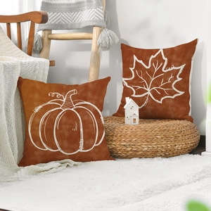 Close-up of fall harvest pumpkin and maple leaf print linen pillow covers on sofa