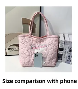 Detail der rosa gesteppten Tragetasche mit Herzmuster, Hunde-Stickerei und Handy-Vergleich