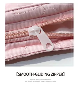 Nahaufnahme eines weißen Kunststoffreißverschlusses an einer rosa gesteppten Tasche