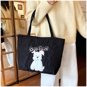 Detail of heart quilting on black nylon tote bag featuring a cute puppy patch and embroidery
