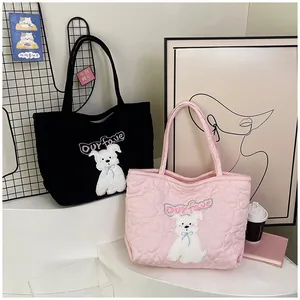 Detailed close-up of quilted tote bags featuring dog embroidery in black and pink