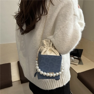 Sac seau imprimé léopard bleu avec poignée en perles et chaîne portée par mannequin